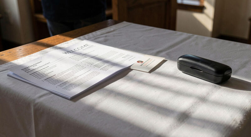 A church welcome table with a printed bulletin and a small card with a QR code.